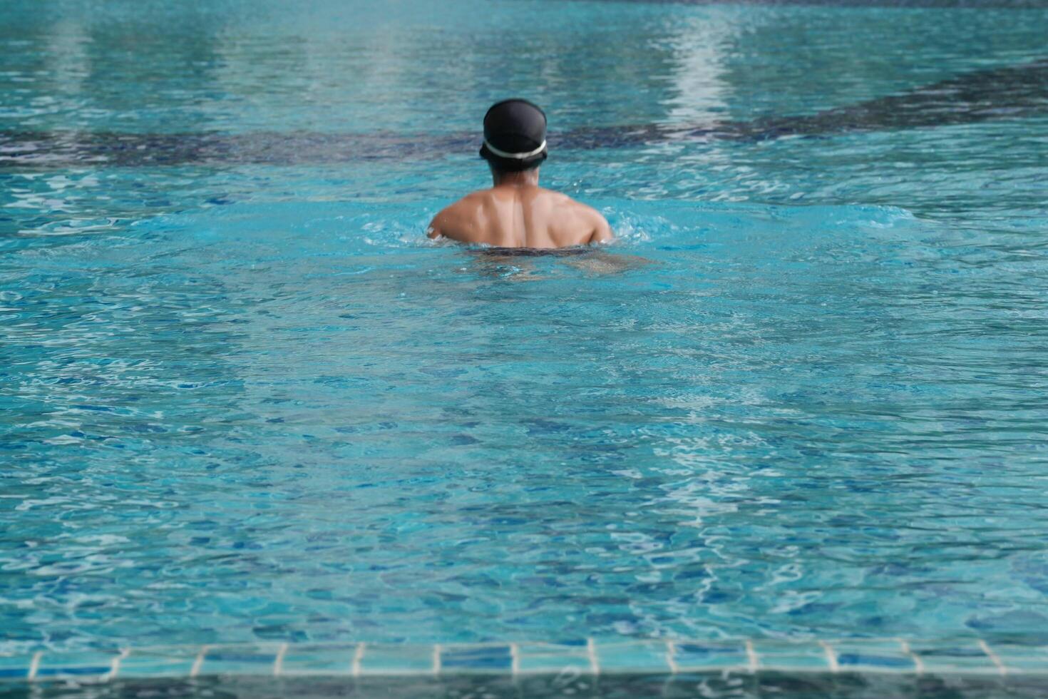 Asian men practicing swimming and preparing to play water polo and stretching and resting for water sports. photo