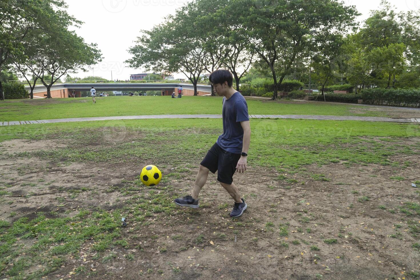 Male soccer players practice using the ball in the park field diligently and happily. photo