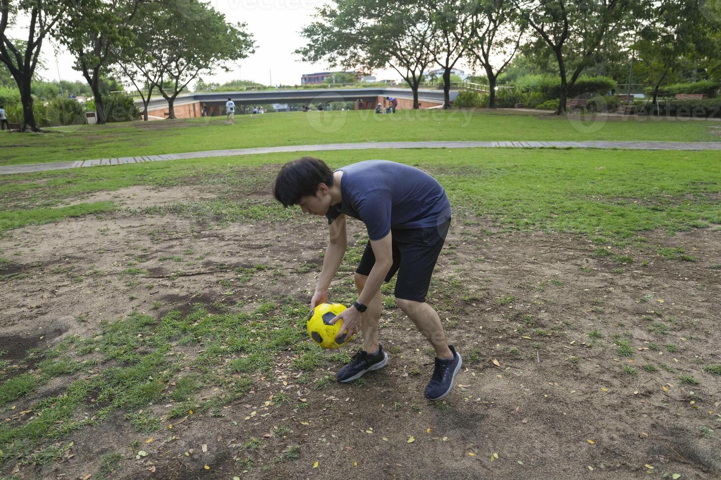 Male soccer players practice using the ball in the park field diligently and happily. photo