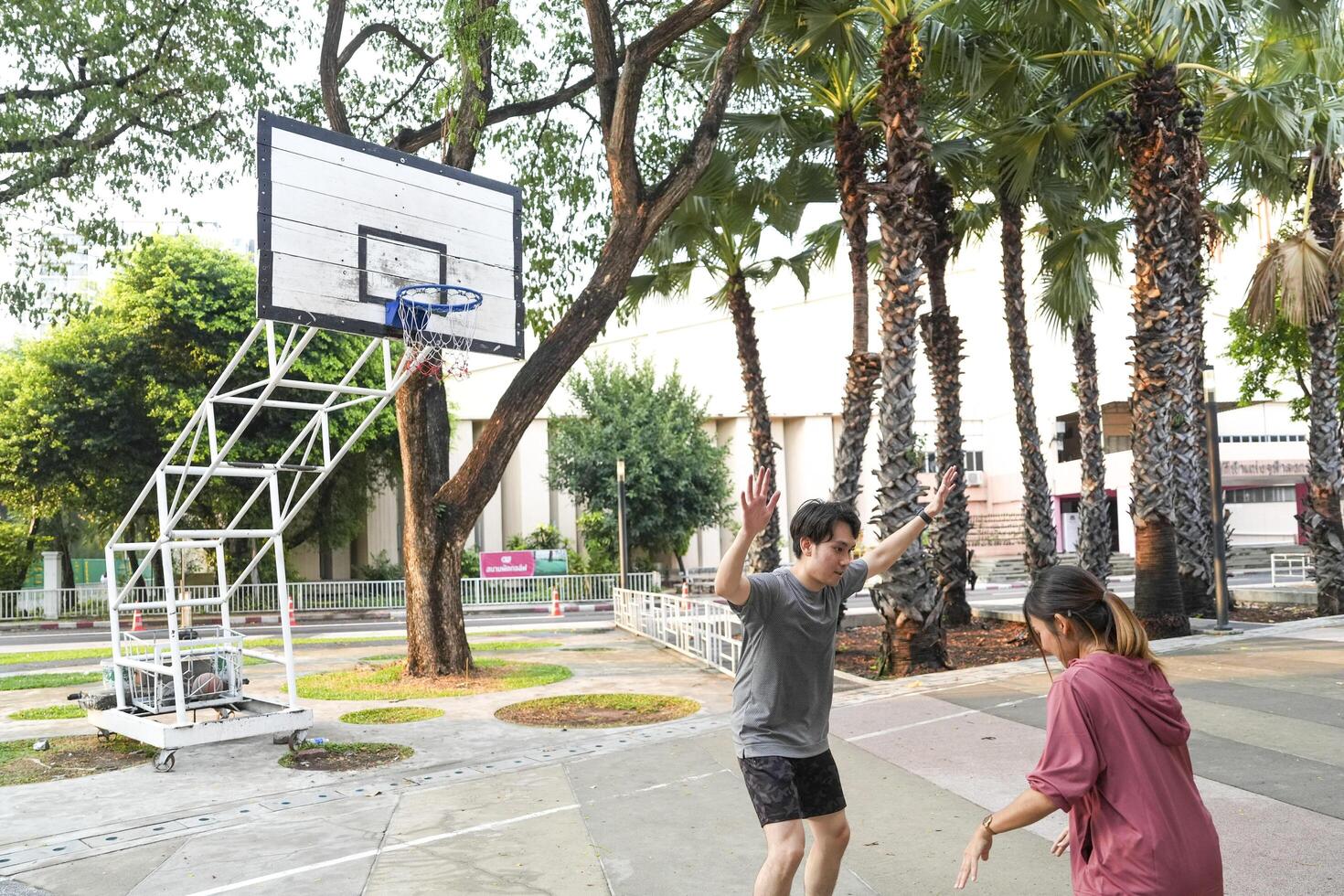 The male and female basketball players practice using the ball in the park court diligently and happily. photo