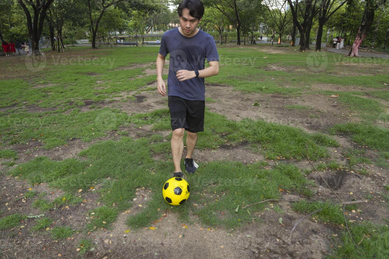 Male soccer players practice using the ball in the park field diligently and happily. photo