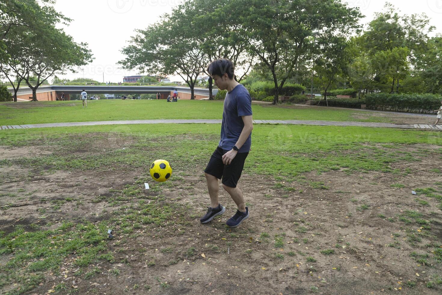 Male soccer players practice using the ball in the park field diligently and happily. photo