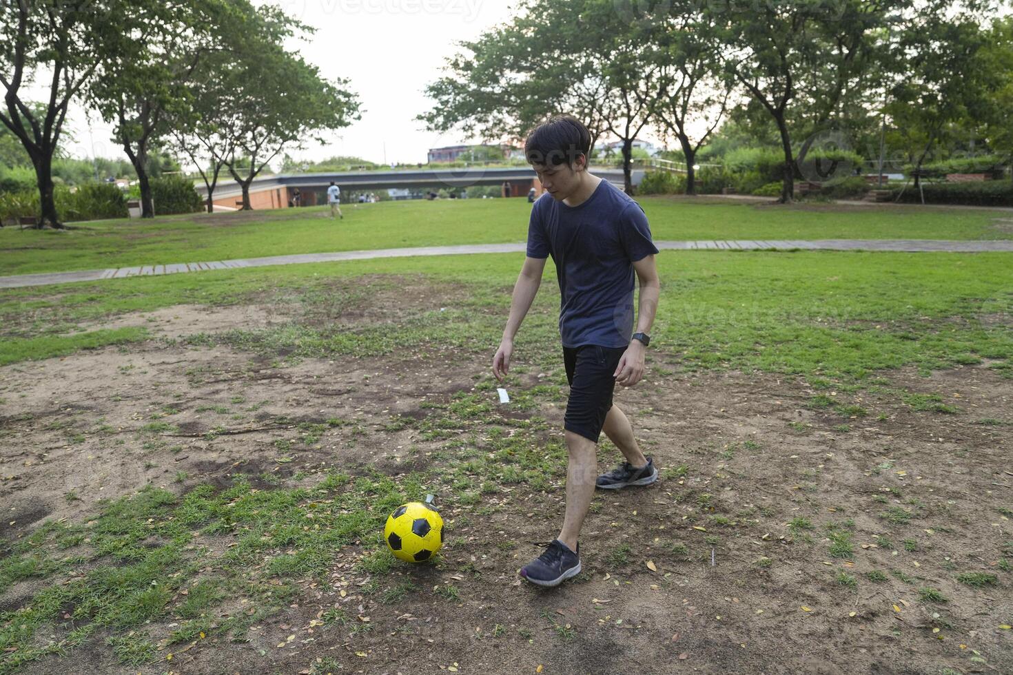 Male soccer players practice using the ball in the park field diligently and happily. photo