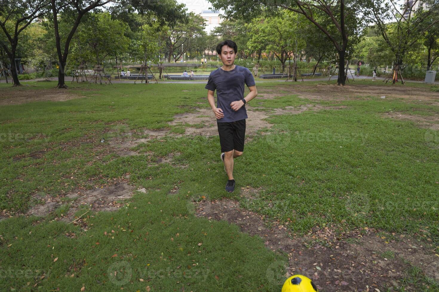 Male soccer players practice using the ball in the park field diligently and happily. photo