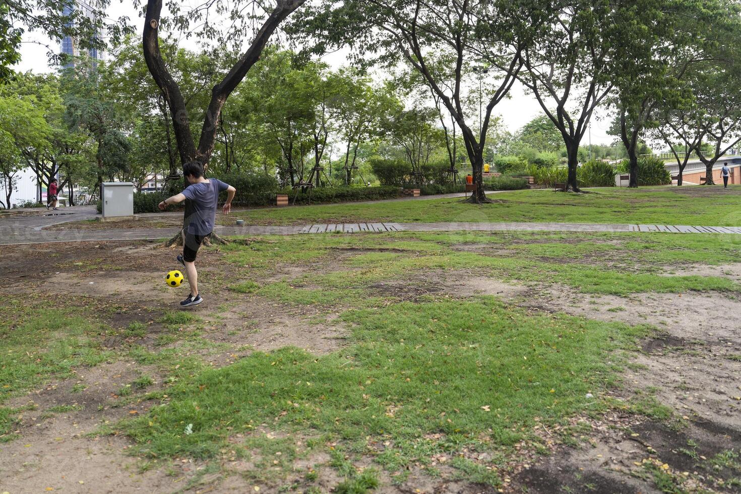 Male soccer players practice using the ball in the park field diligently and happily. photo