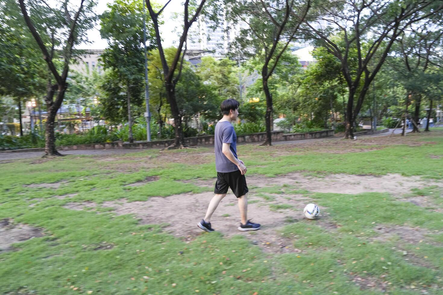 Asian man are running and Kicking ball for playing a soccer at outdoor park. photo
