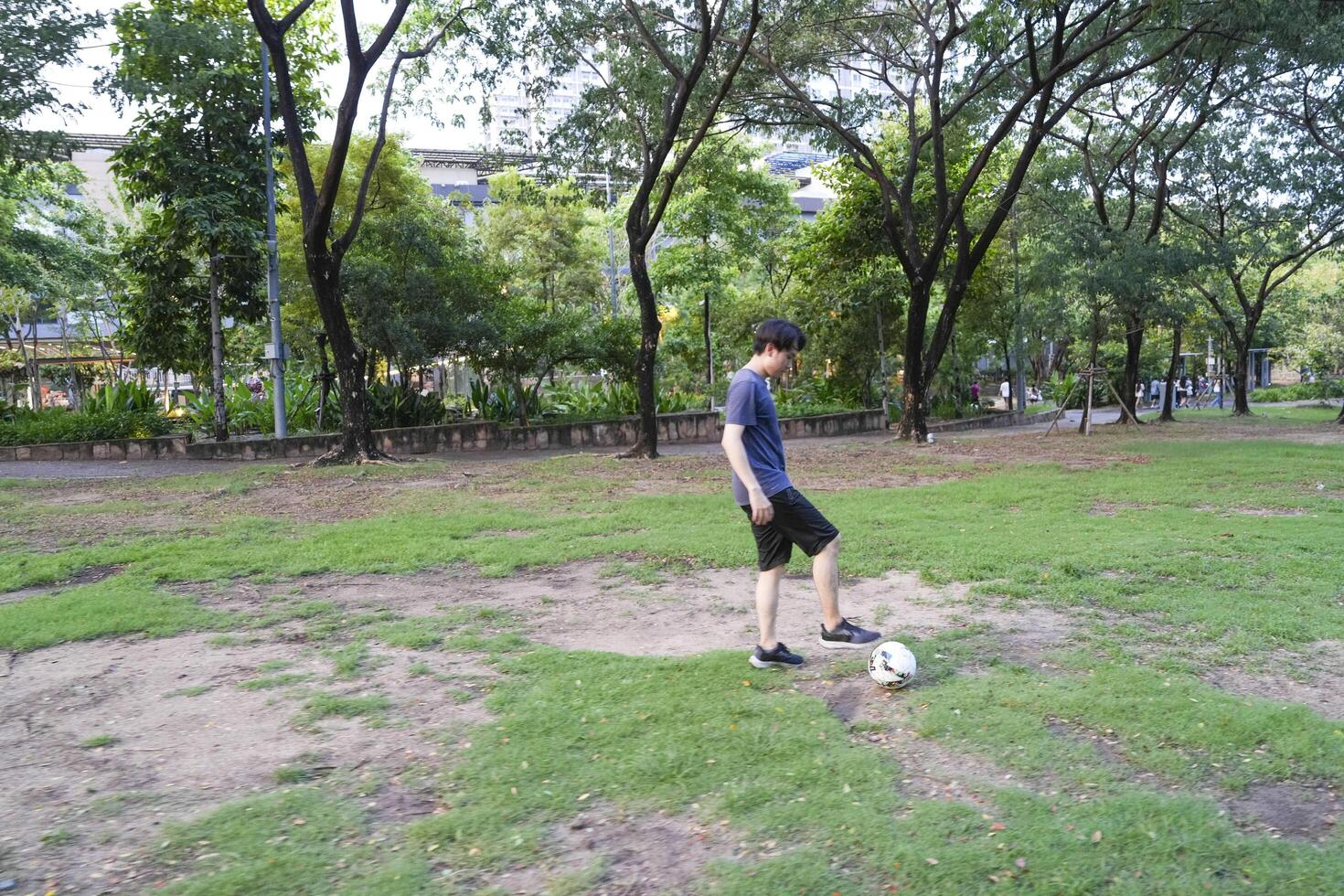 Asian man are running and Kicking ball for playing a soccer at outdoor park. photo