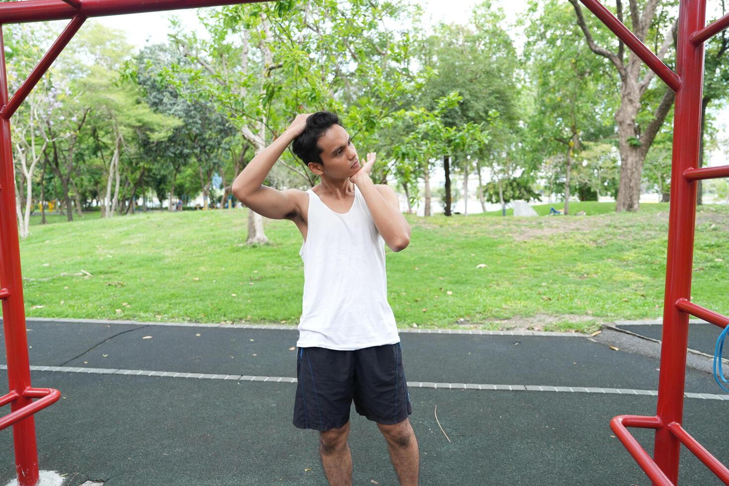 Asian man practicing gymnastics doing gymnastics bar and hoop exercises and stretching and resting for sports. photo