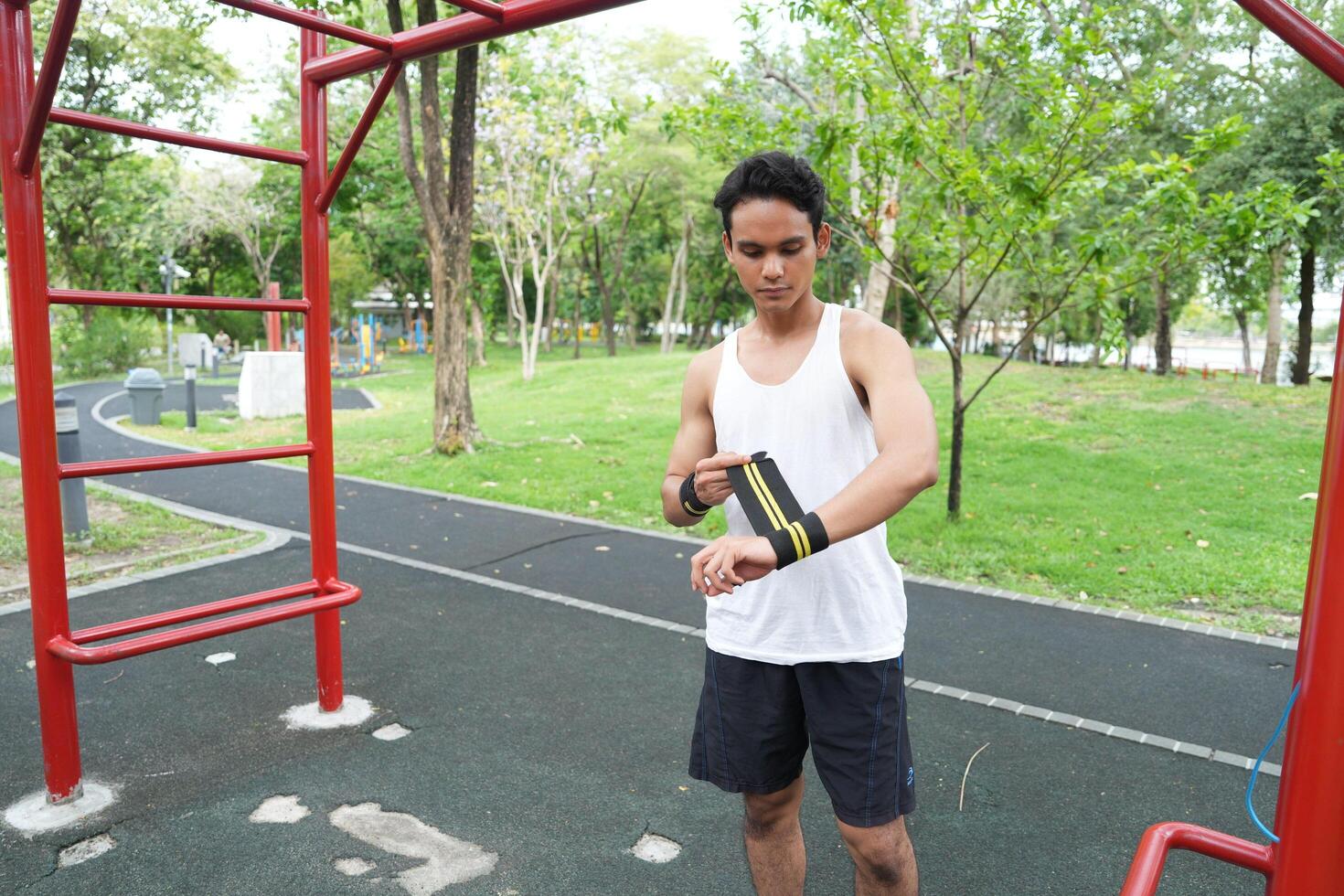 Asian man practicing gymnastics doing gymnastics bar and hoop exercises and stretching and resting for sports. photo