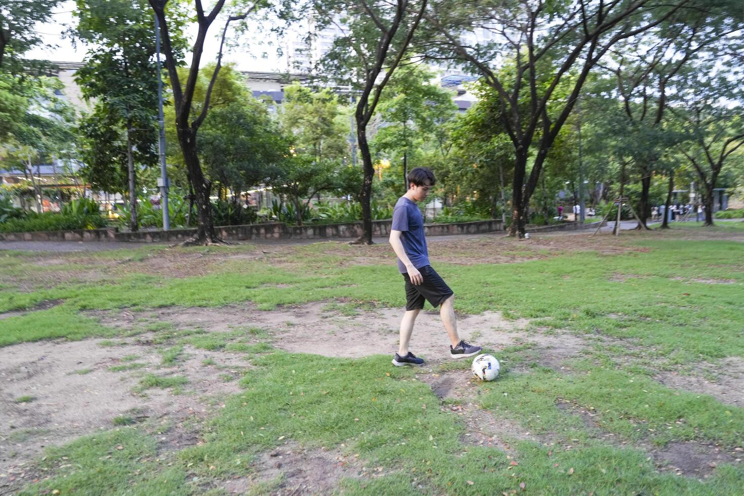Asian man are running and Kicking ball for playing a soccer at outdoor park. photo