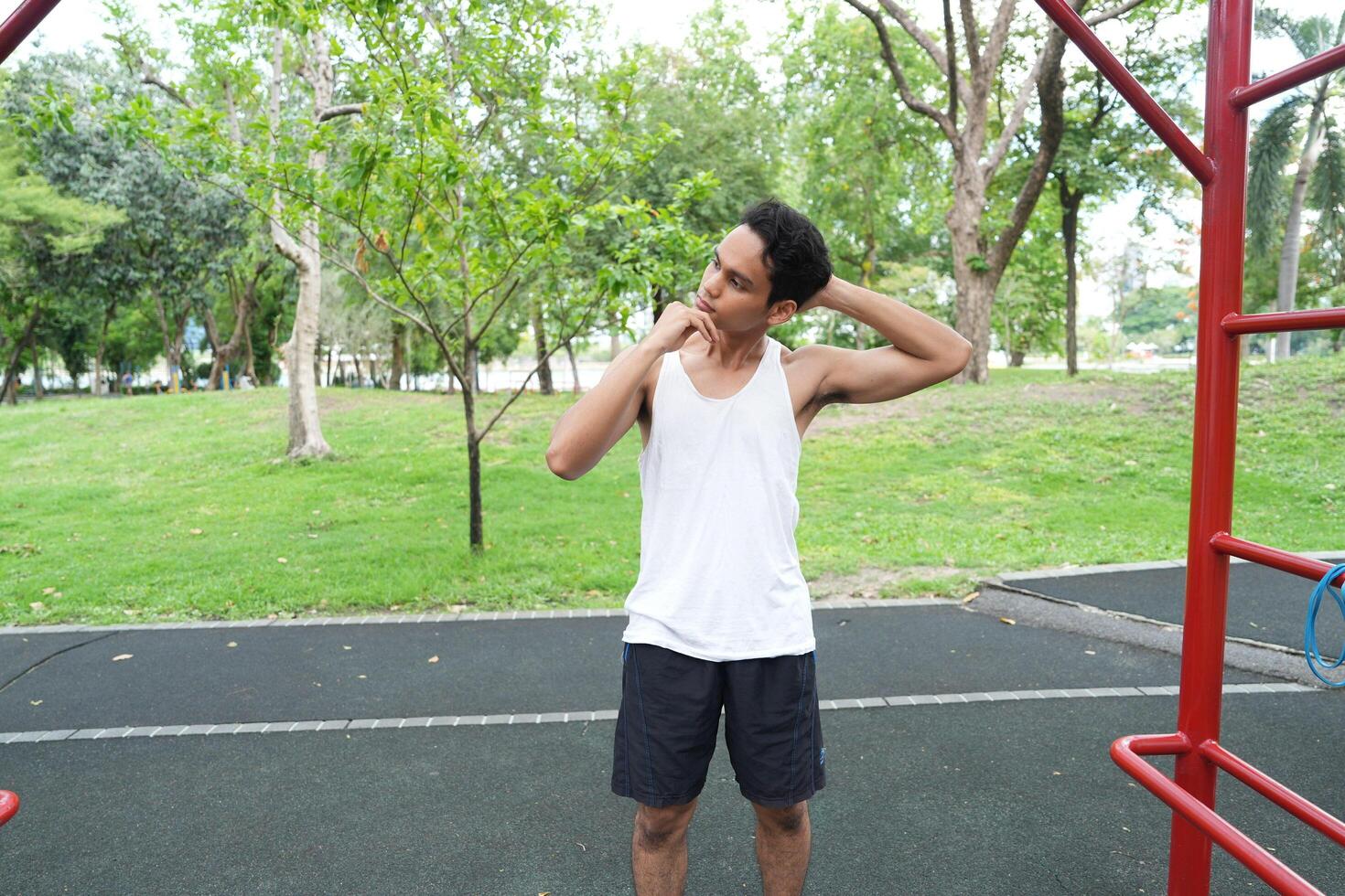 Asian man practicing gymnastics doing gymnastics bar and hoop exercises and stretching and resting for sports. photo