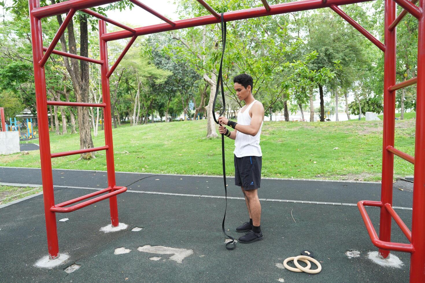 Asian man practicing gymnastics doing gymnastics bar and hoop exercises and stretching and resting for sports. photo