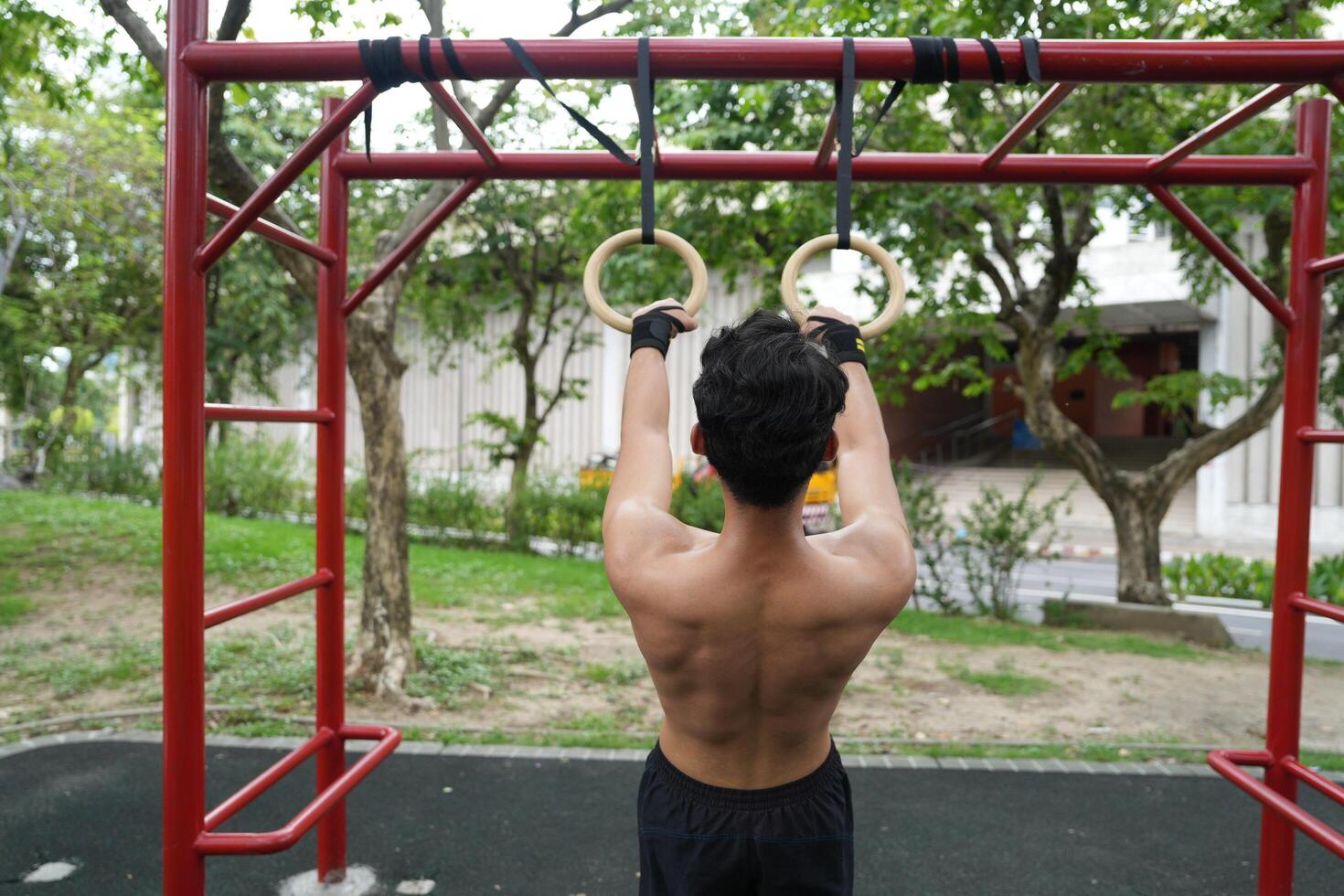 Asian man practicing gymnastics, doing gymnastics bar and hoop exercises and stretching, resting for sports. photo