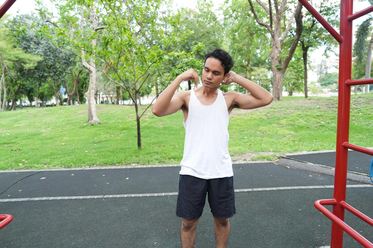 Asian man practicing gymnastics doing gymnastics bar and hoop exercises and stretching and resting for sports. photo