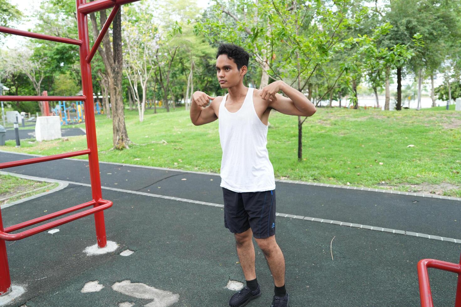 Asian man practicing gymnastics doing gymnastics bar and hoop exercises and stretching and resting for sports. photo