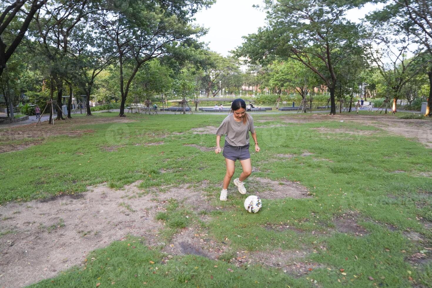 female soccer players practice using the ball in the park field diligently and happily. photo
