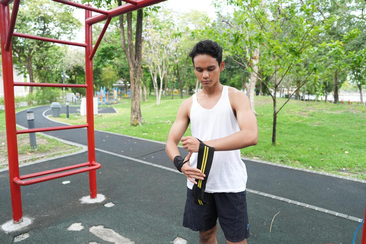 Asian man practicing gymnastics doing gymnastics bar and hoop exercises and stretching and resting for sports. photo
