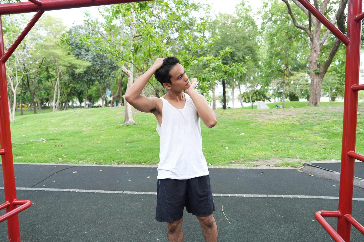 Asian man practicing gymnastics doing gymnastics bar and hoop exercises and stretching and resting for sports. photo