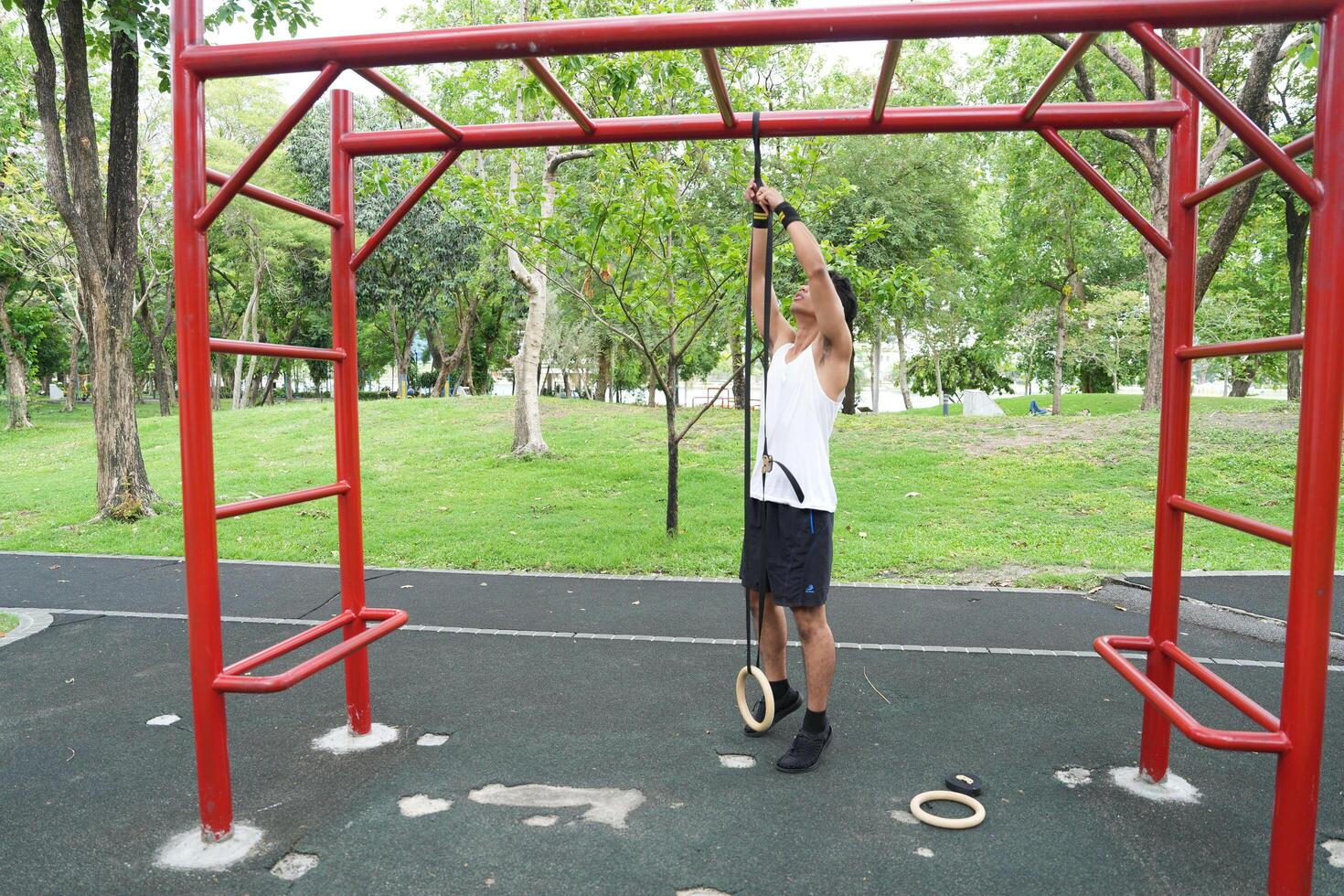 Asian man practicing gymnastics doing gymnastics bar and hoop exercises and stretching and resting for sports. photo