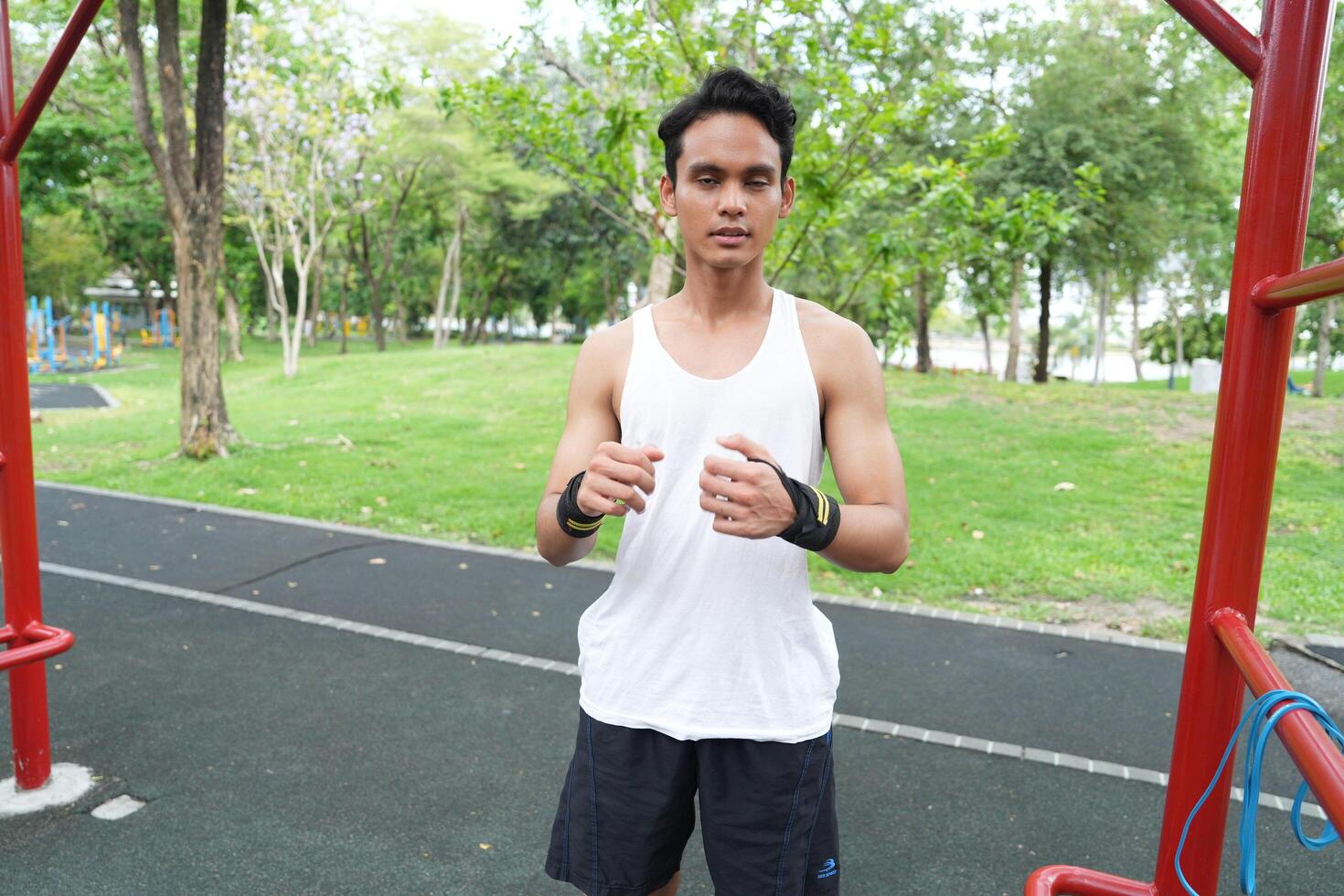 Asian man practicing gymnastics doing gymnastics bar and hoop exercises and stretching and resting for sports. photo