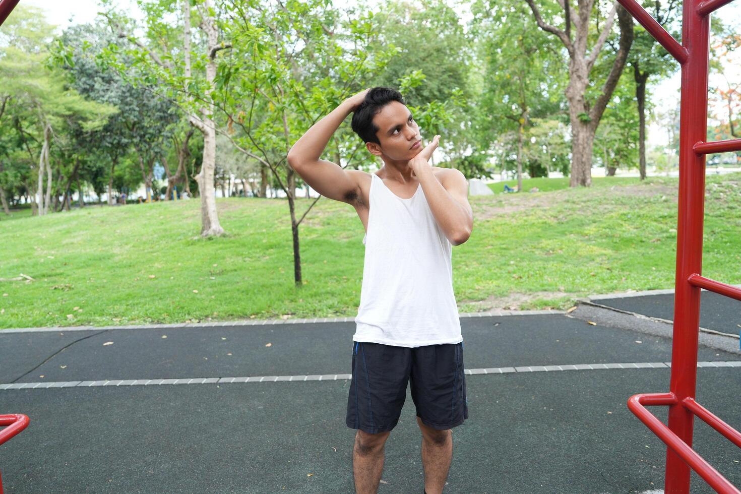 Asian man practicing gymnastics doing gymnastics bar and hoop exercises and stretching and resting for sports. photo