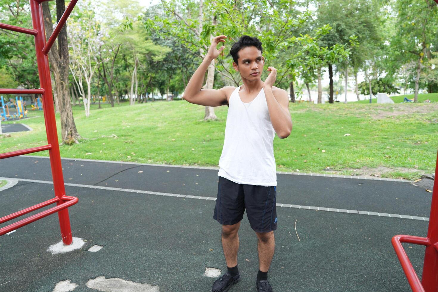 Asian man practicing gymnastics doing gymnastics bar and hoop exercises and stretching and resting for sports. photo