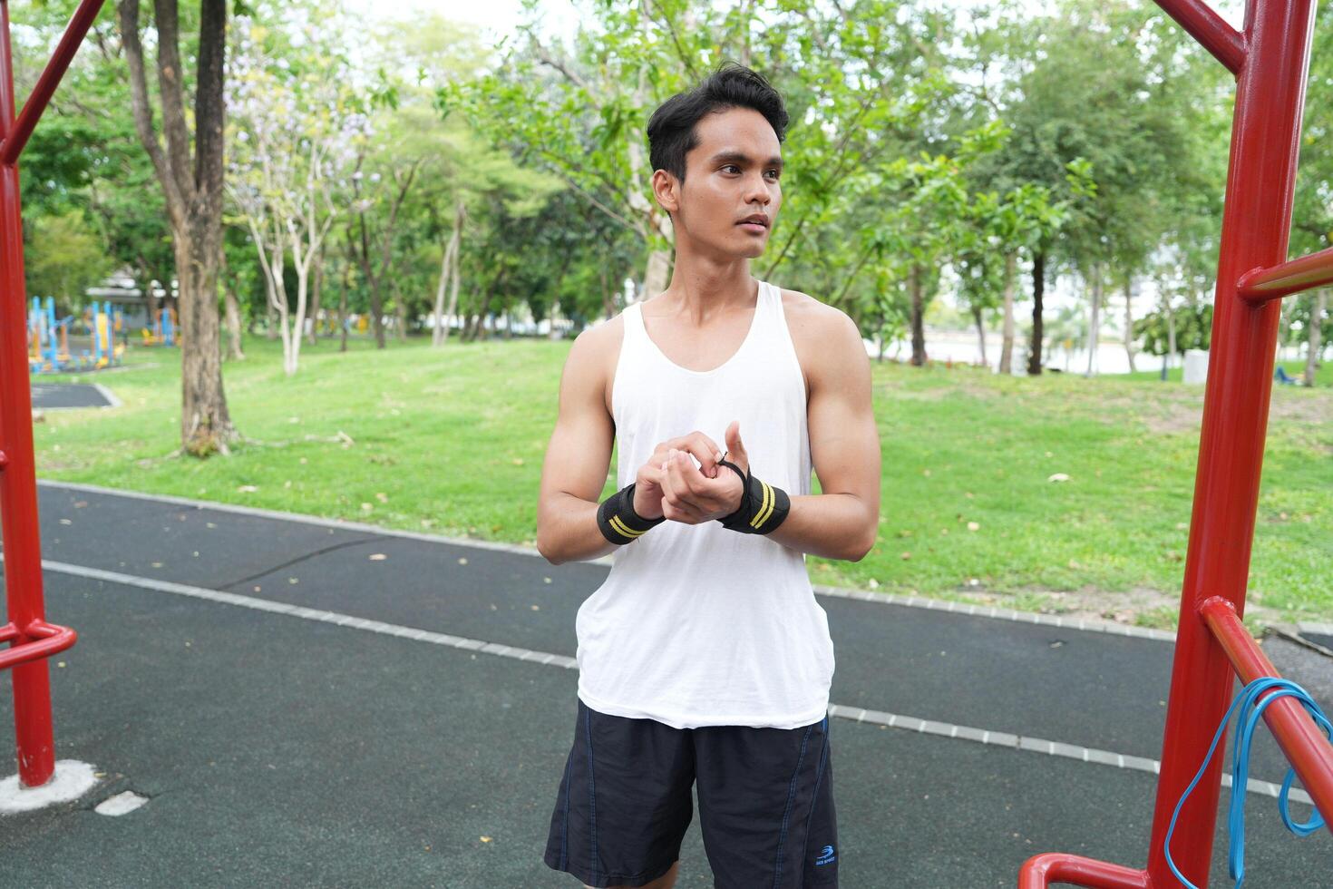 Asian man practicing gymnastics doing gymnastics bar and hoop exercises and stretching and resting for sports. photo