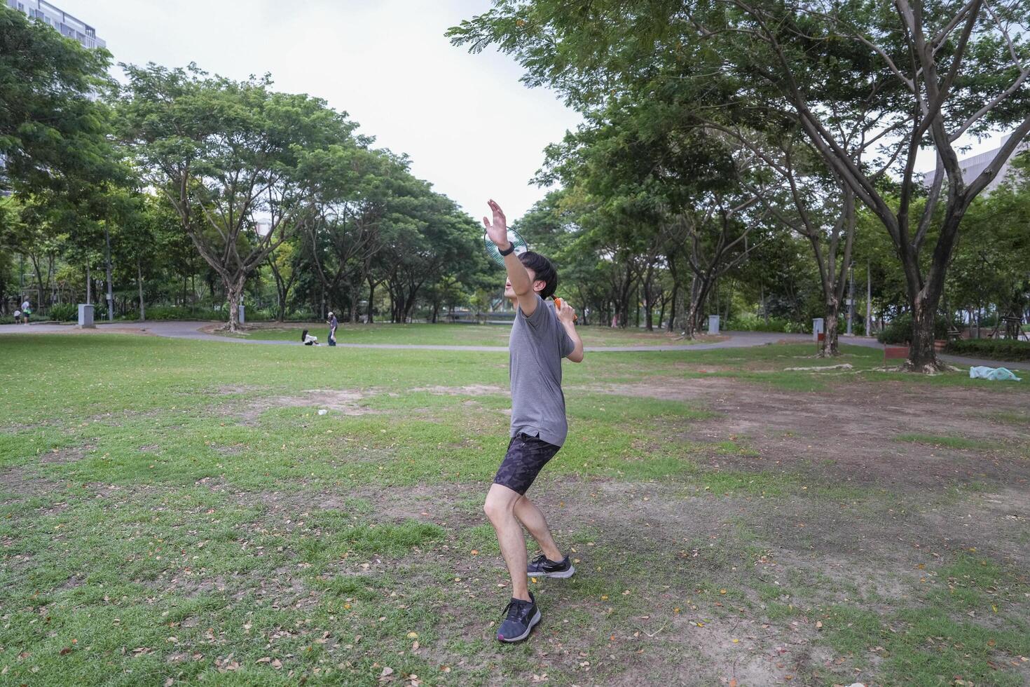 Young people play badminton and repair diligently in the park area. photo