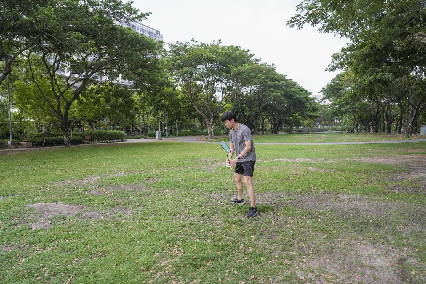 Young people play badminton and repair diligently in the park area. photo