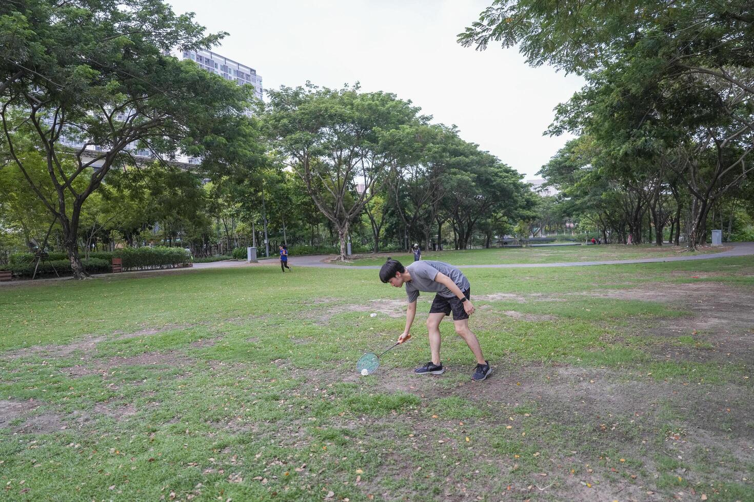 Young people play badminton and repair diligently in the park area. photo