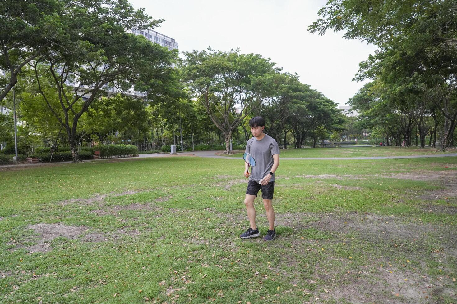 Young people play badminton and repair diligently in the park area. photo