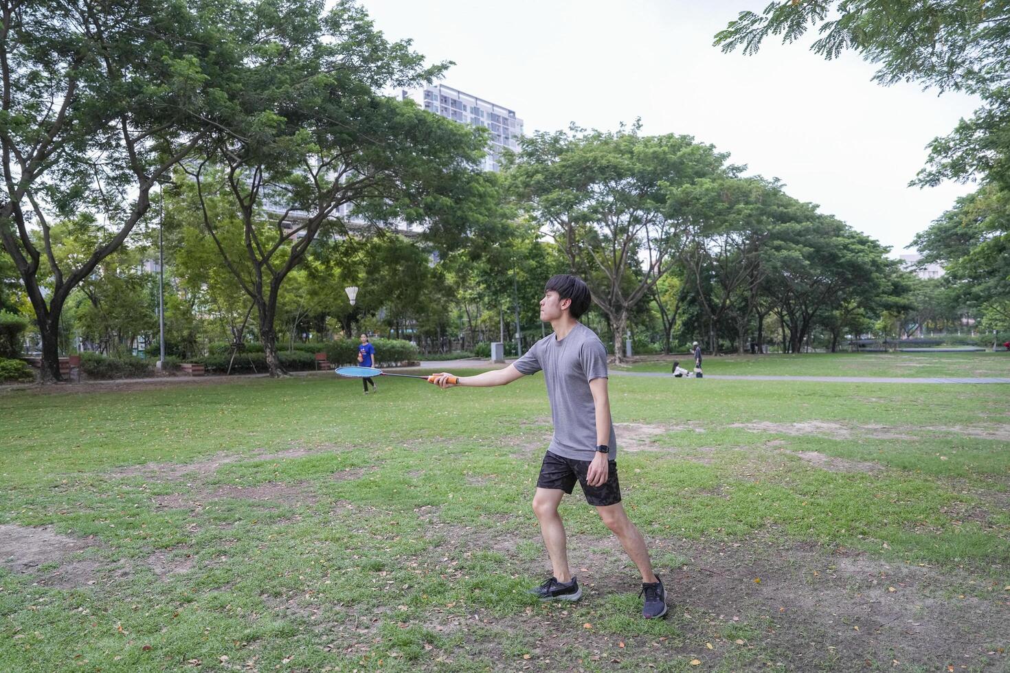 Young people play badminton and repair diligently in the park area. photo