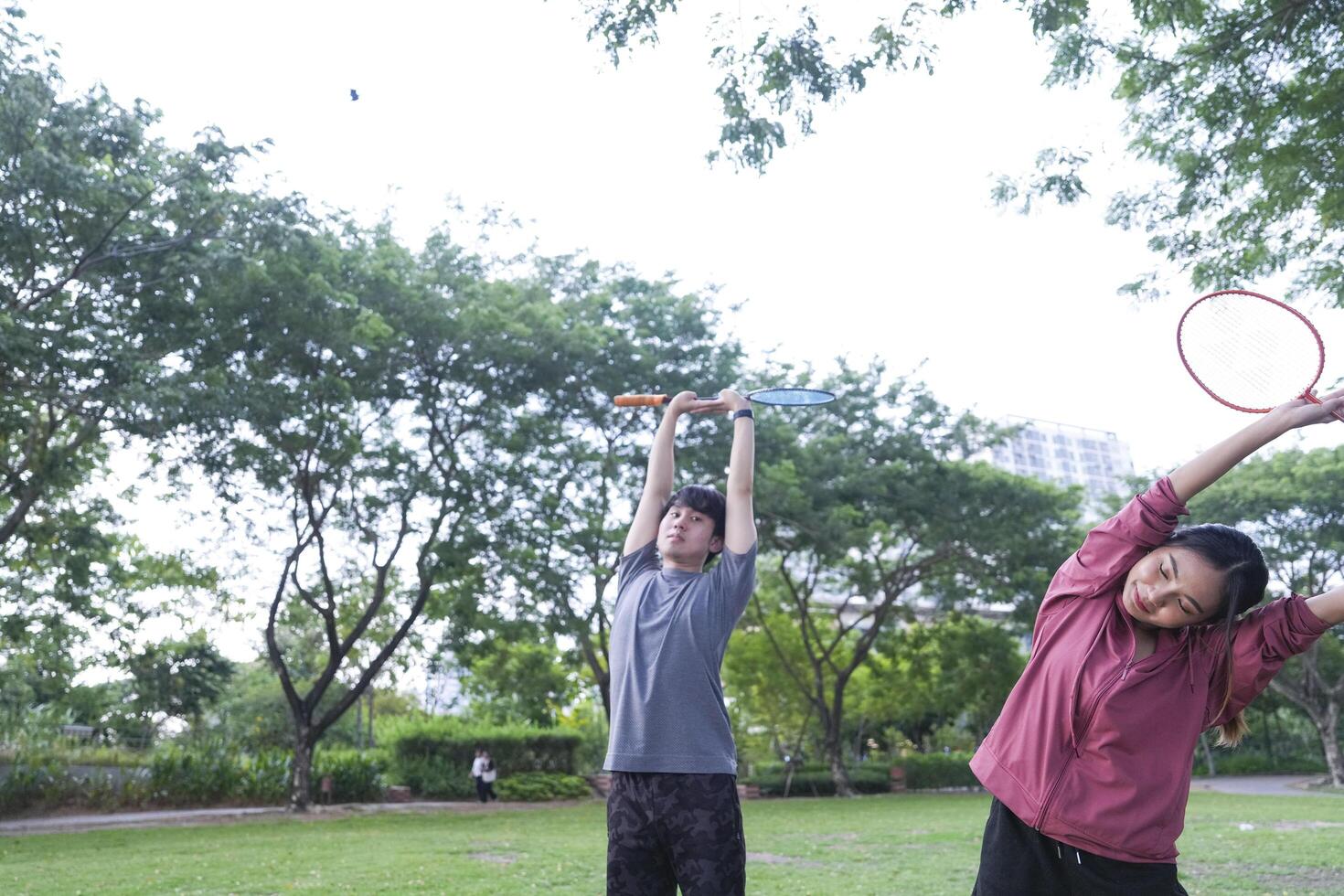 Young people play badminton and repair diligently in the park area. photo