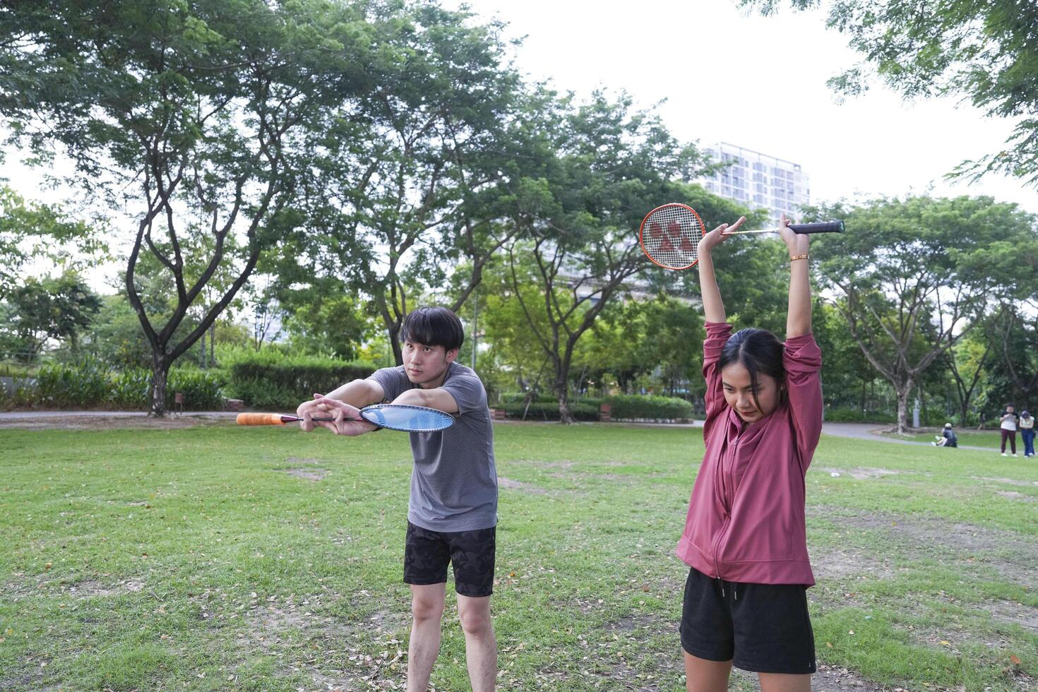 Young people play badminton and repair diligently in the park area. photo