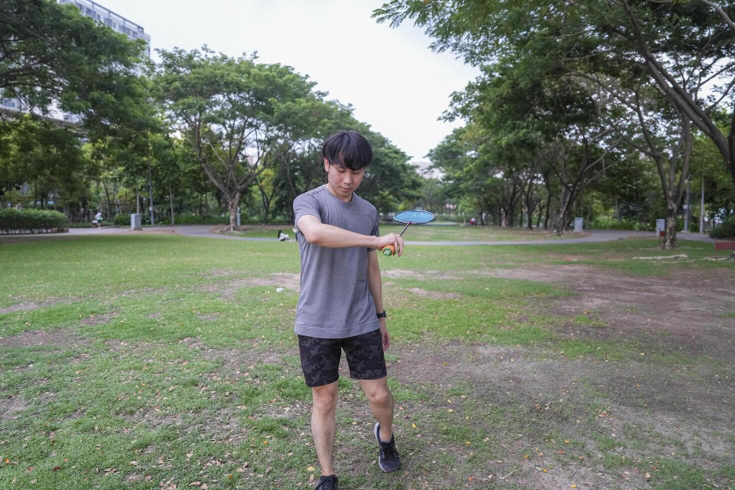 Young people play badminton and repair diligently in the park area. photo