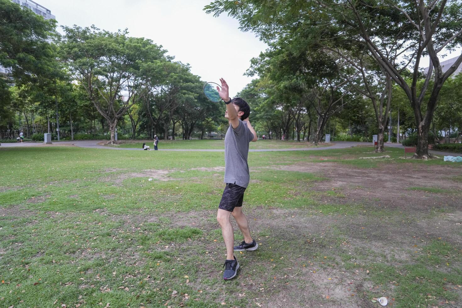 Young people play badminton and repair diligently in the park area. photo