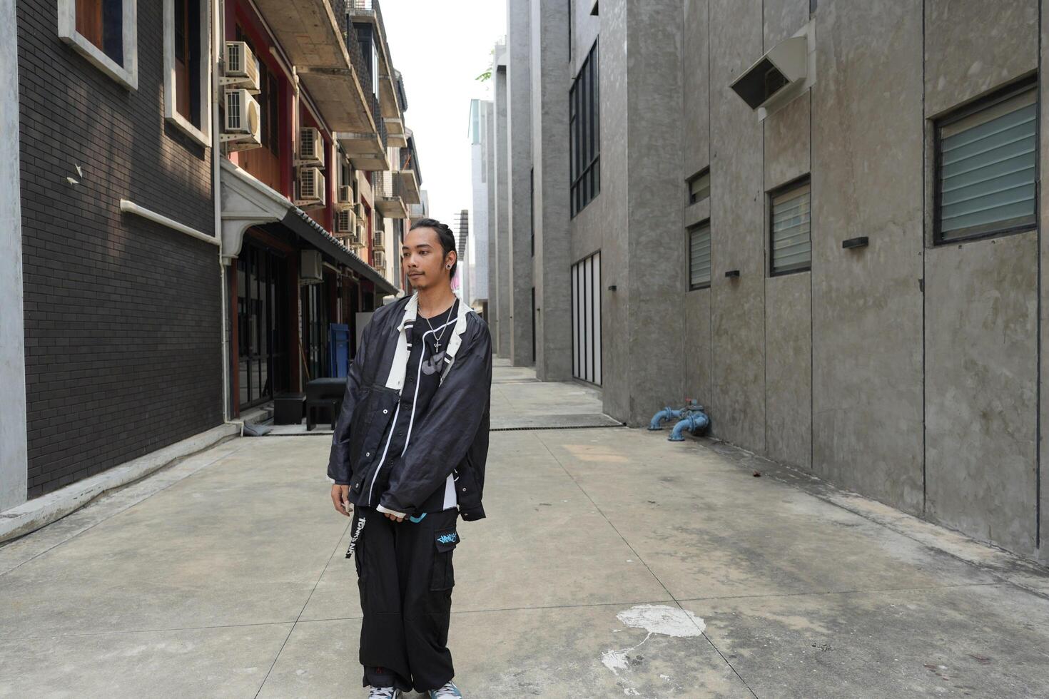 ASian man is dancing in hip hop style at outdoor space. Professional solo dancer is performing in public area. photo