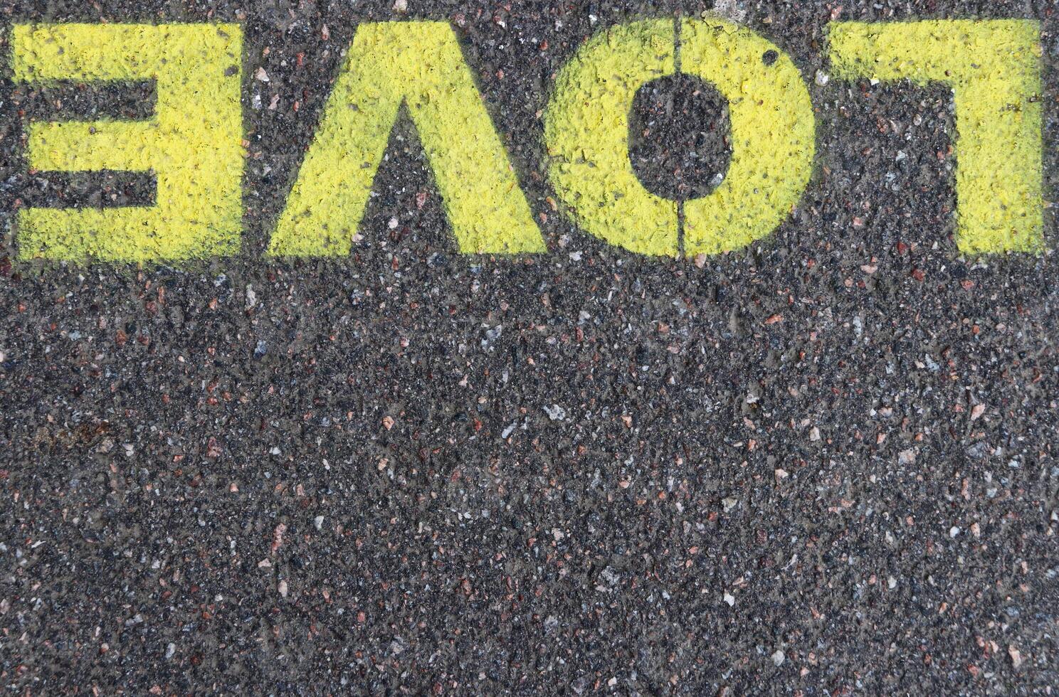 Road asphalt texture. Bitumen structure with painted love word. photo