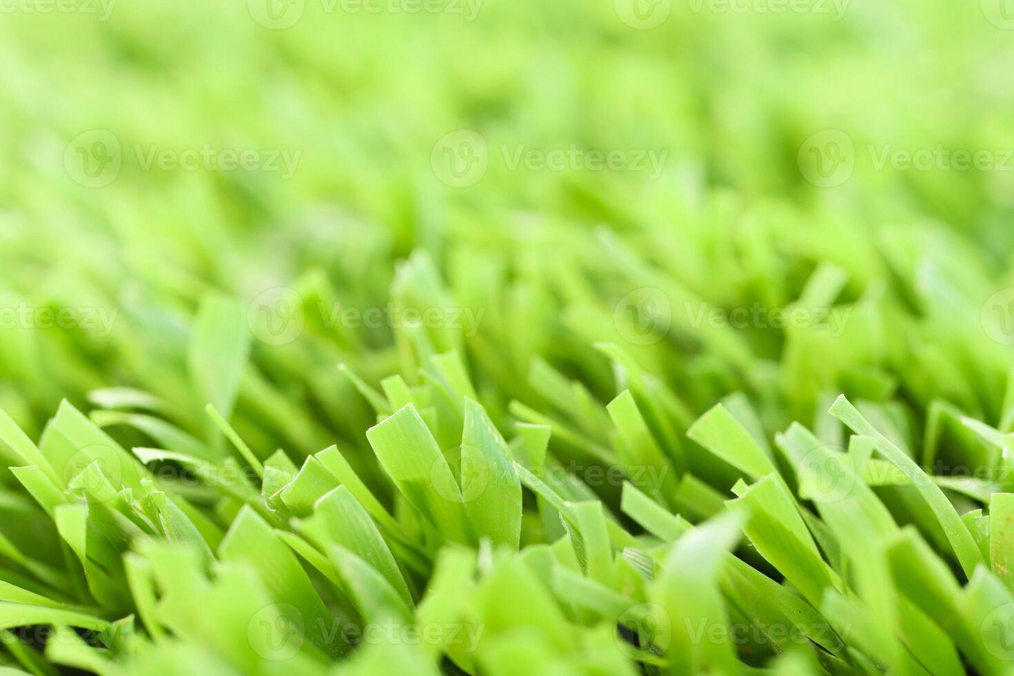 Green artificial grass texture with blurred background. Modern s photo