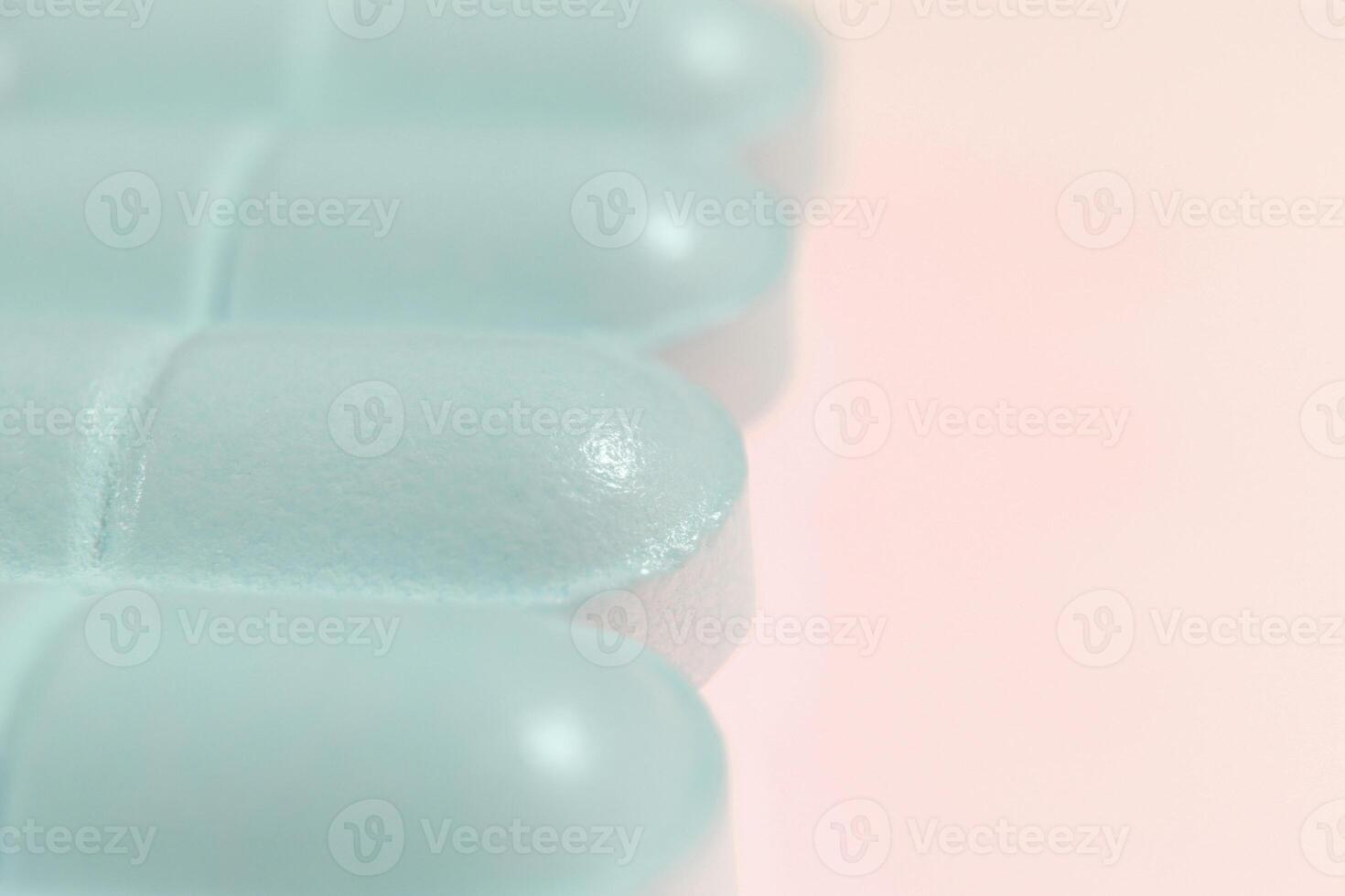 Medicine Tablets. Blue Pharmacy Pills on Peach Background. Macro Closeup. photo