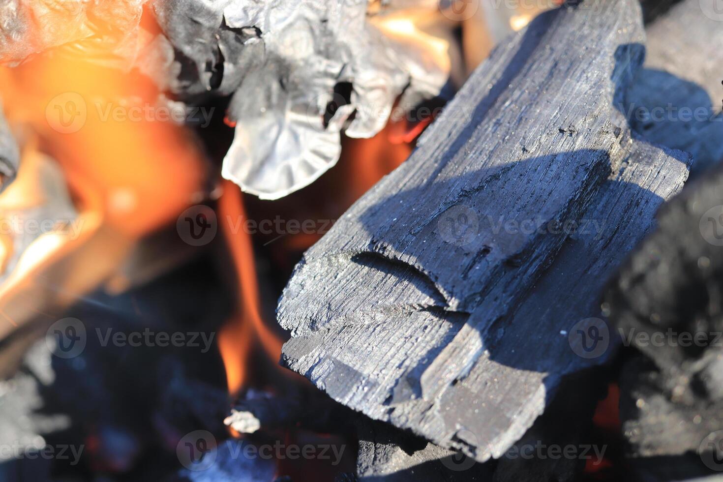 Black coal in outdoor picnic bonfire. Coal detailed texture with fire photo