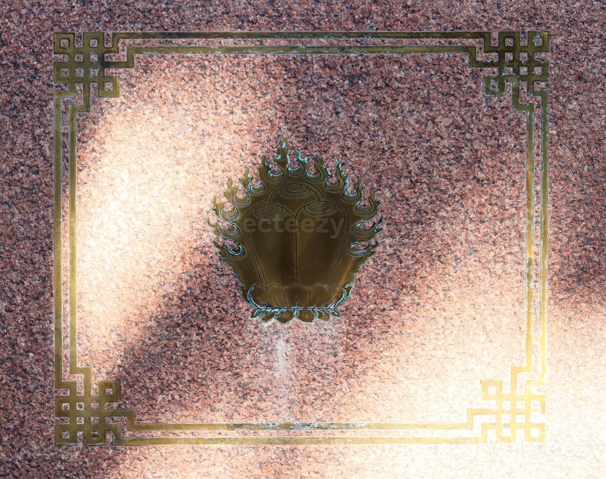 Oriental bronze decoration ornament on granite surface. Buddhist traditional sangha of Russia. Datsan Gunzehoyney. photo