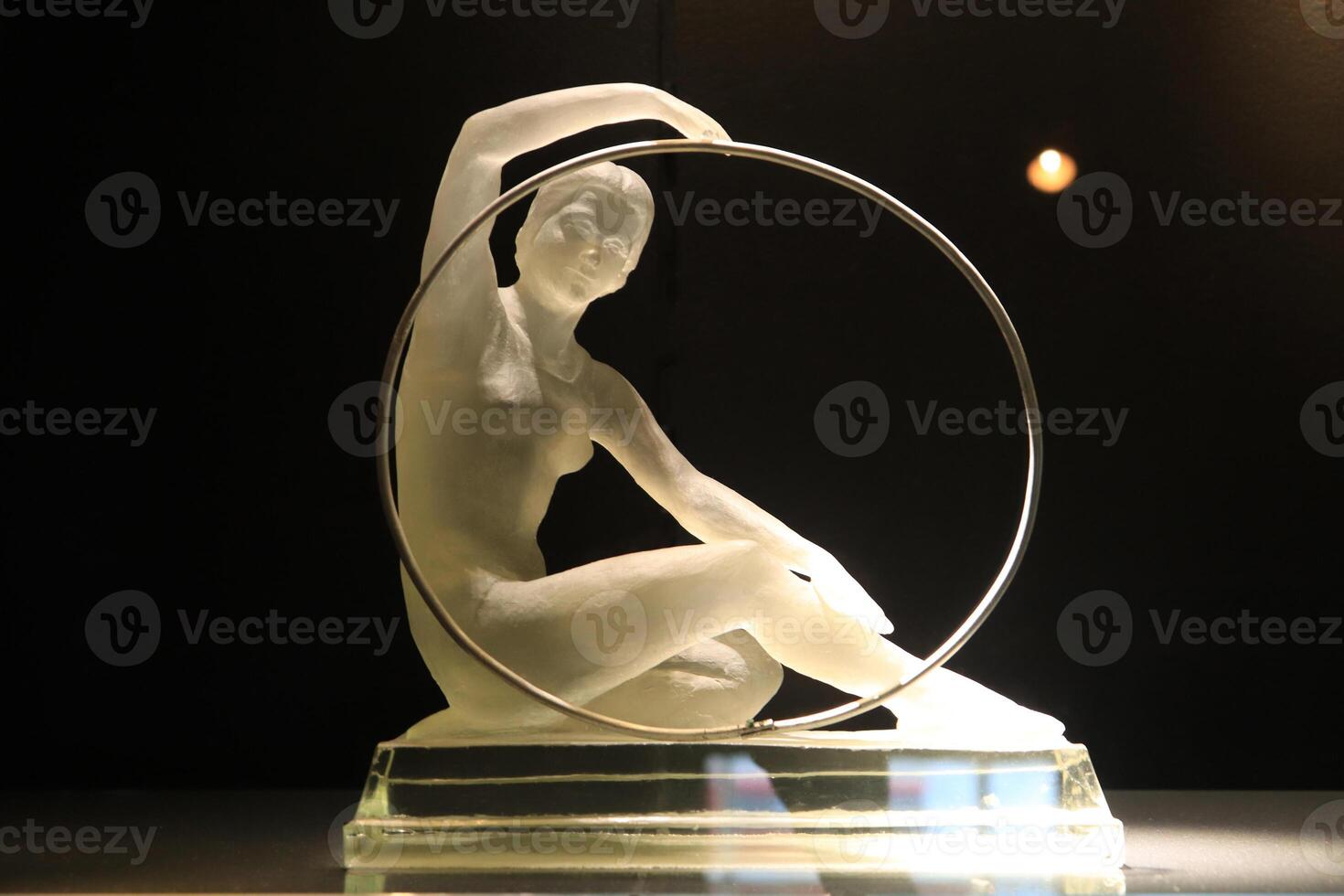 A statuette of a girl from the glass holding a hoop. photo