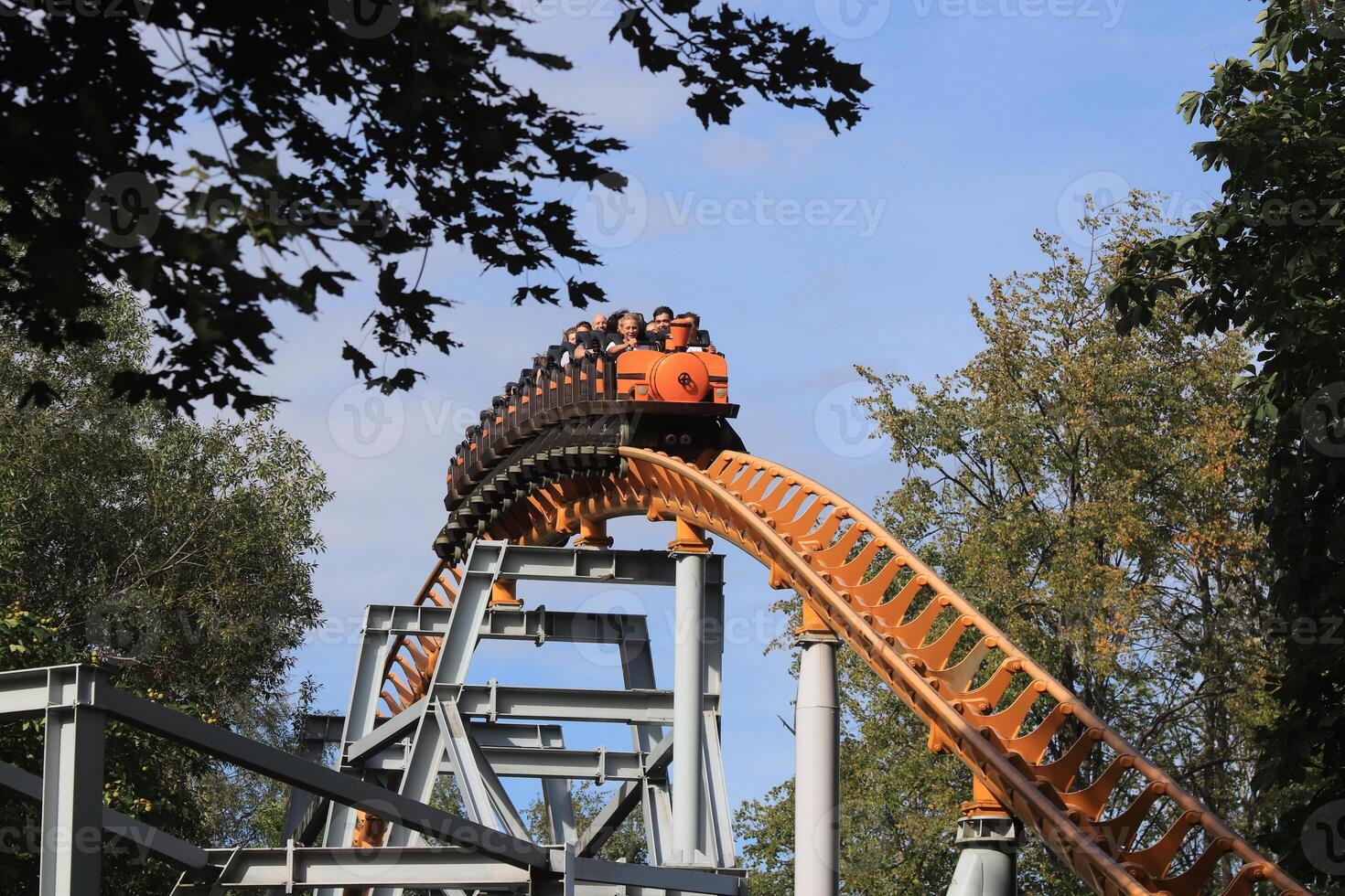 Ascending to the top rollercoaster rail train with peoples. Amusement park Divo-island. Saint-Petersburg. photo