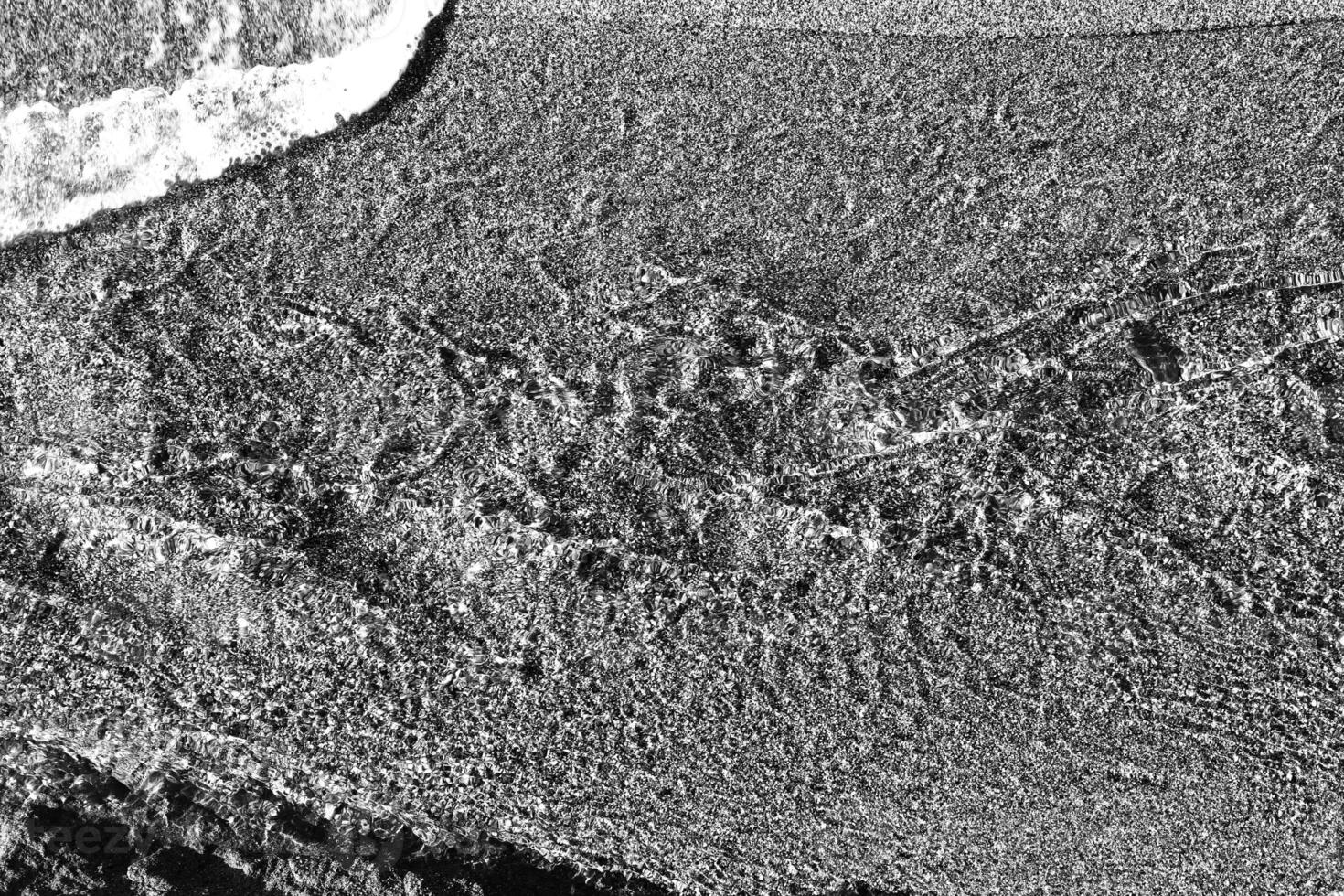 Clear stream with sand on background. Black and white. photo