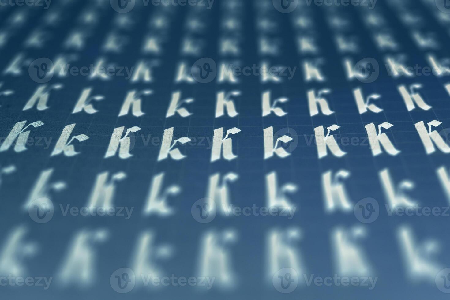Lettering white on dark blue practice writing worksheet. Handwriting symbol filling pattern. Calligraphic letter K learning skills paper page. Calligraphy letters K background. photo