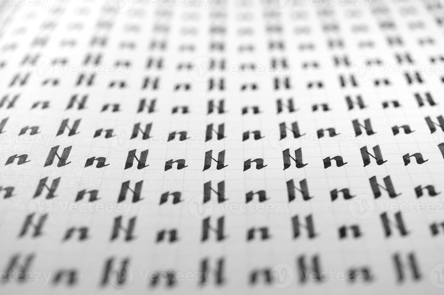 Handwriting black and white symbol filling pattern. Calligraphic letter N learning skills paper page. Calligraphy letters n background. Lettering practice writing worksheet. photo