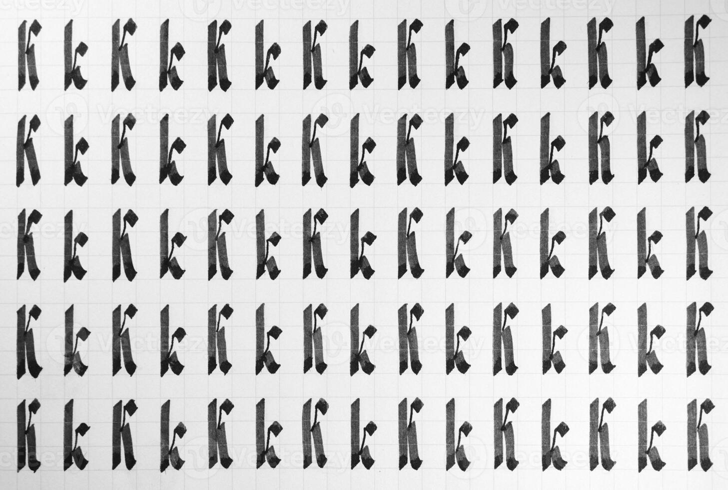 Calligraphy black and white letters K background. Lettering practice writing worksheet. Handwriting symbol filling pattern. Calligraphic letter k learning skills paper page. photo