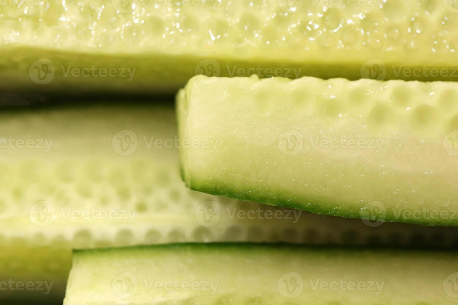 Sliced cucumber pieces. Organic healthy food slices. Filling background. photo