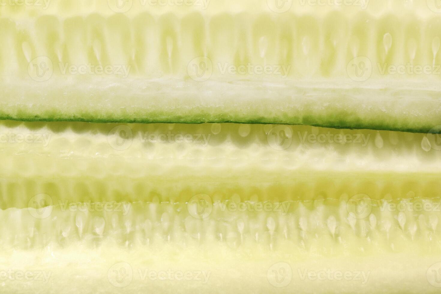 Sliced cucumber pieces. Organic healthy food slices. Filling background. photo